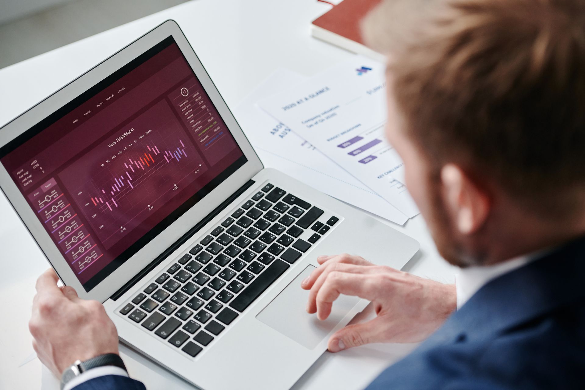 Executive reviewing a dashboard on a laptop with printed strategy pages beside